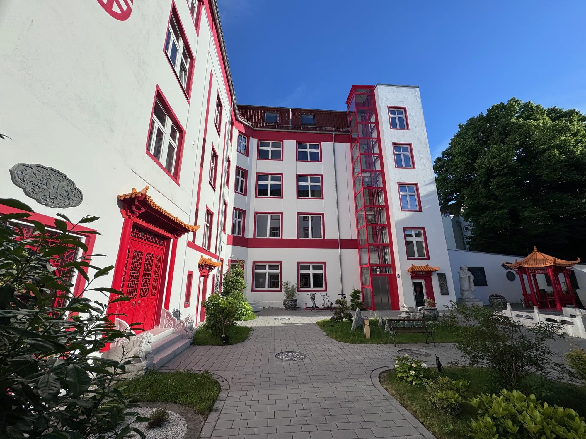 Innenhof mit Rasenflächen, Sträuchern und geschwungenen Wegen