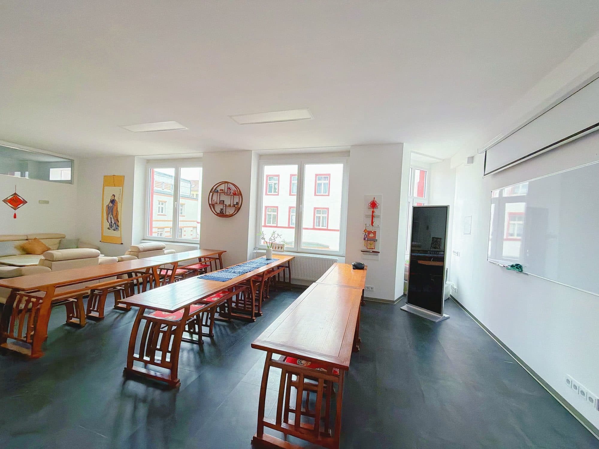 Seminarraum mit langen Tischreihen und chinesischer Wanddekoration
